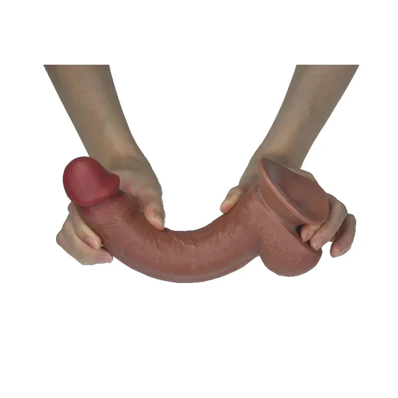 Person holding a large, brown, flexible dildo against a white background