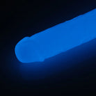 Blue glowing dildo against a black background