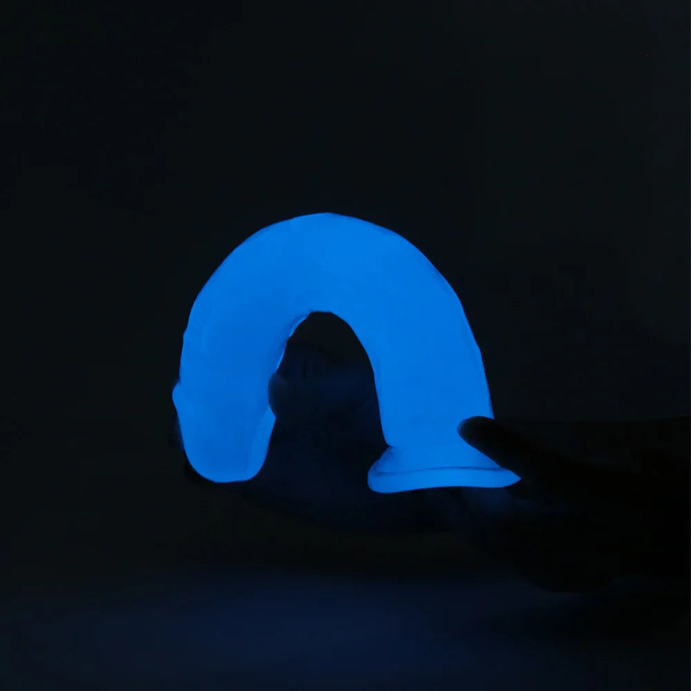 Blue glowing arch-shaped dildo held by a hand against a black background